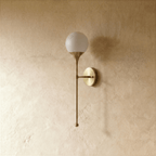 Clérachic wall lamp in satin brass, front view of the glass globe shade and its tapering rod.