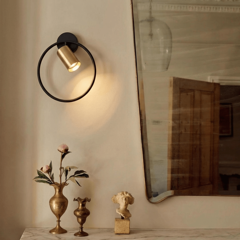 Clérachic black ring wall light lit low in a dim room