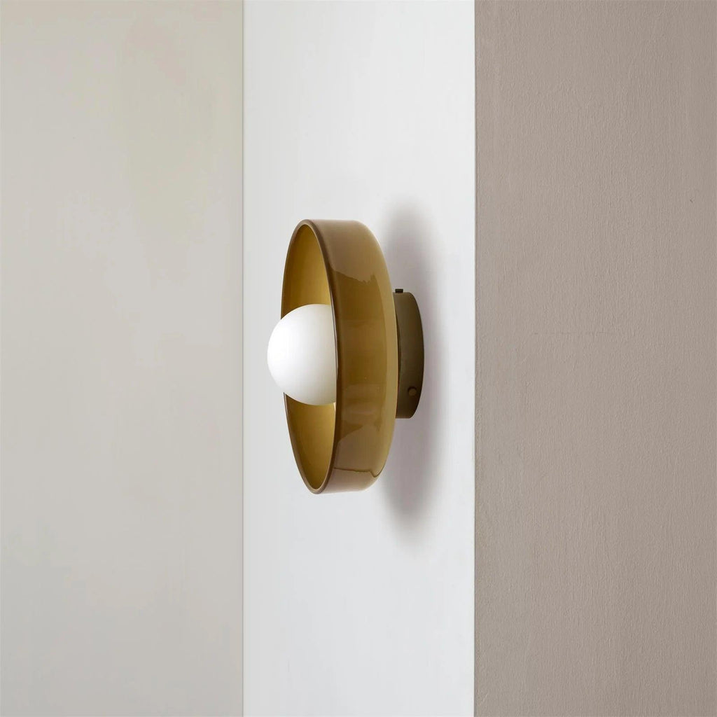 A brown-toned disc light mounted on a wall corner, a different mount from this Clérachic ceiling light.