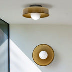 This Clérachic ceiling light and a matching wall light share a stairwell with a glass panel, both in warm brown glass.