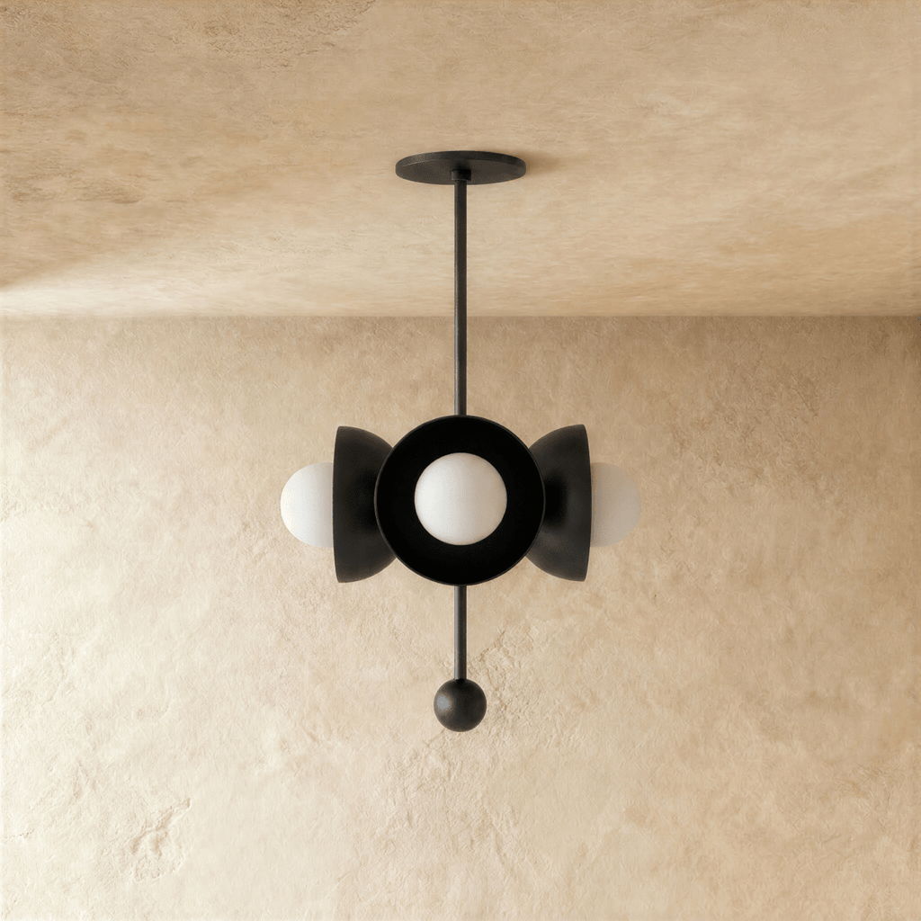 Clérachic disc-and-globe pendant light in matte black, shown from a slightly closer studio angle on a plaster wall.