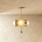 Clérachic disc-and-globe pendant light in polished brass, hung from a plaster ceiling and photographed in studio.