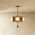 Clérachic disc-and-globe pendant light in vintage brass, hung from a plaster ceiling and photographed in studio.