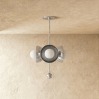 Clérachic disc-and-globe pendant light in chrome, shown from a slightly closer studio angle on a plaster wall.