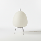 Rice paper table lamp on its tripod base giving off a warm glow
