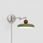 Plug-in round disc wall lamp casting soft light on a wall