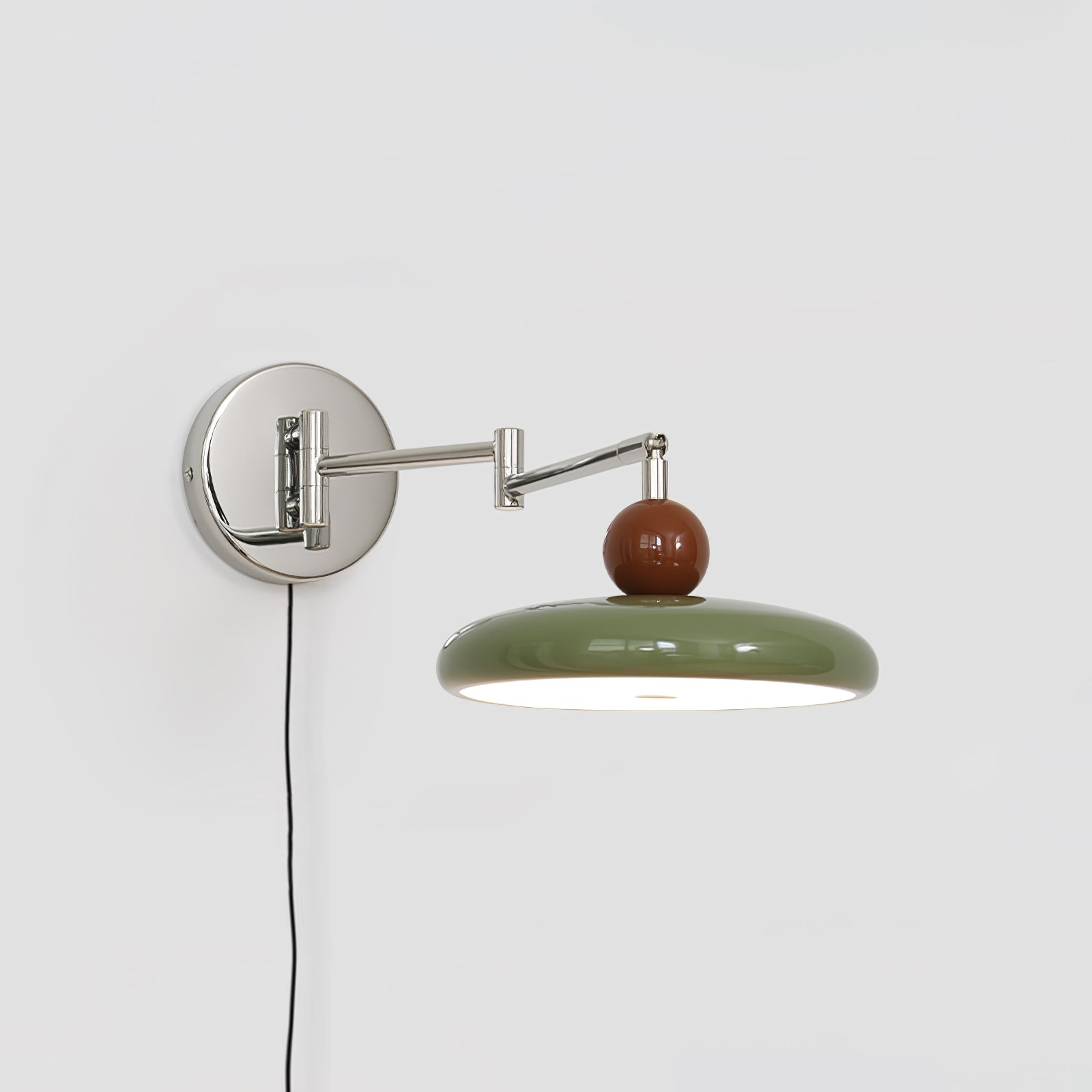 Plug-in round disc wall lamp casting soft light on a wall