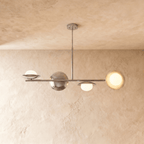 Clérachic pendant light in a bright chrome finish, its spheres and opal glass globes suspended below a ceiling.
