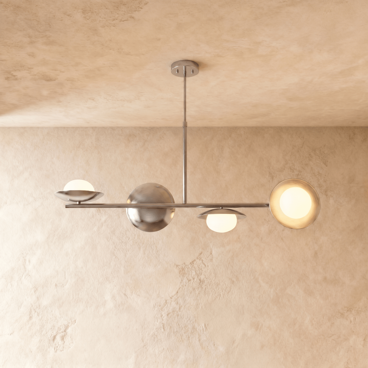 Clérachic pendant light in a bright chrome finish, its spheres and opal glass globes suspended below a ceiling.