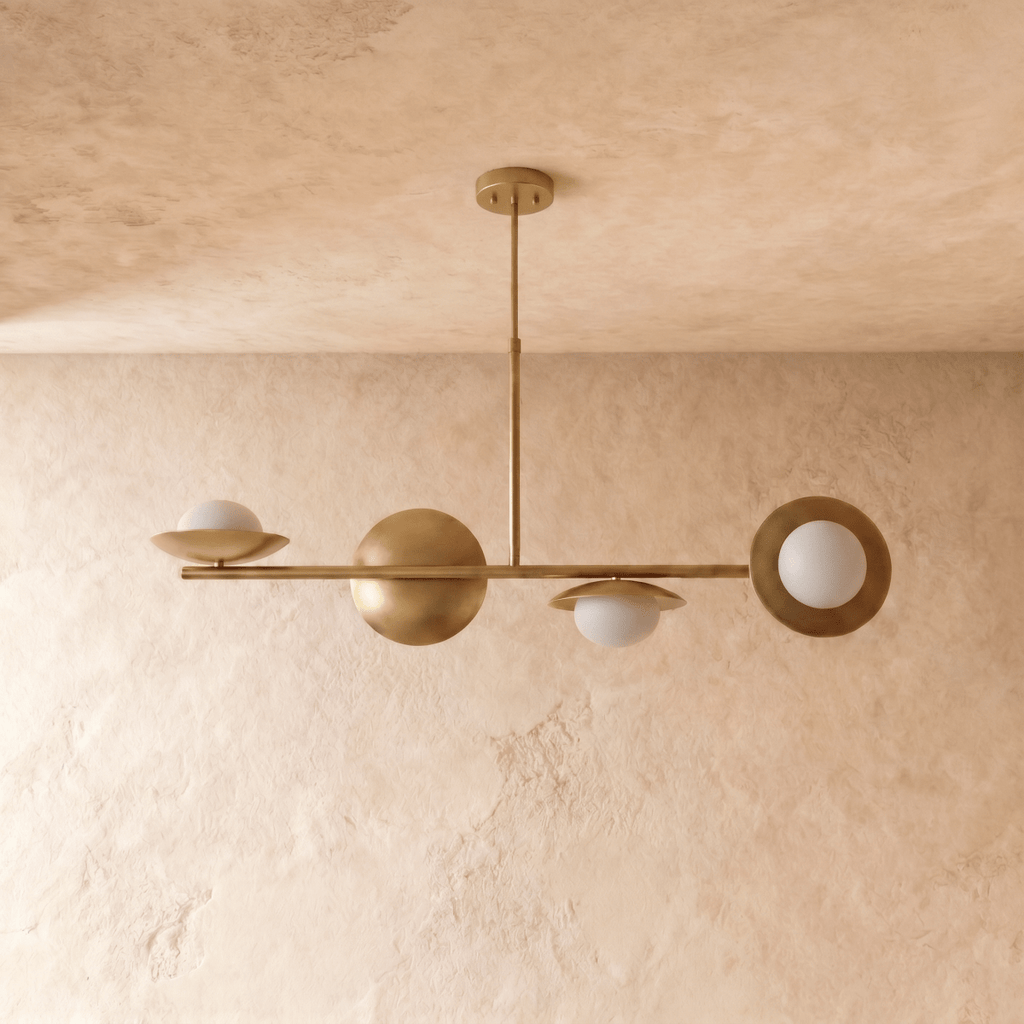 Clérachic pendant light in polished brass, the asymmetric bar with glass globes shown from another angle.