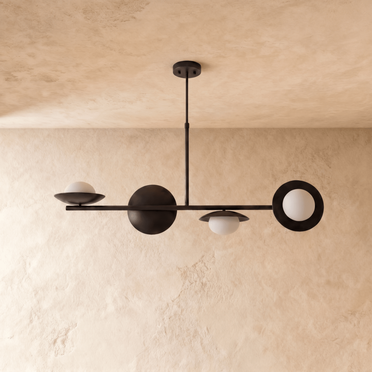 Clérachic pendant light in matte black, the linear bar with round discs and glass globes seen from the side.