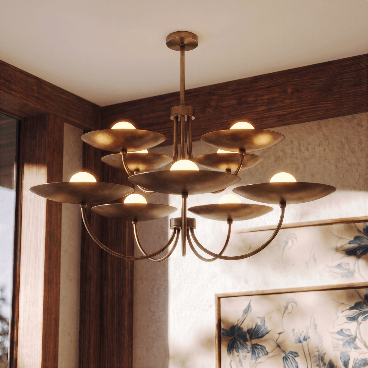Clérachic vintage brass two-tier disc chandelier lit in a wood-panelled room beside a framed floral print.
