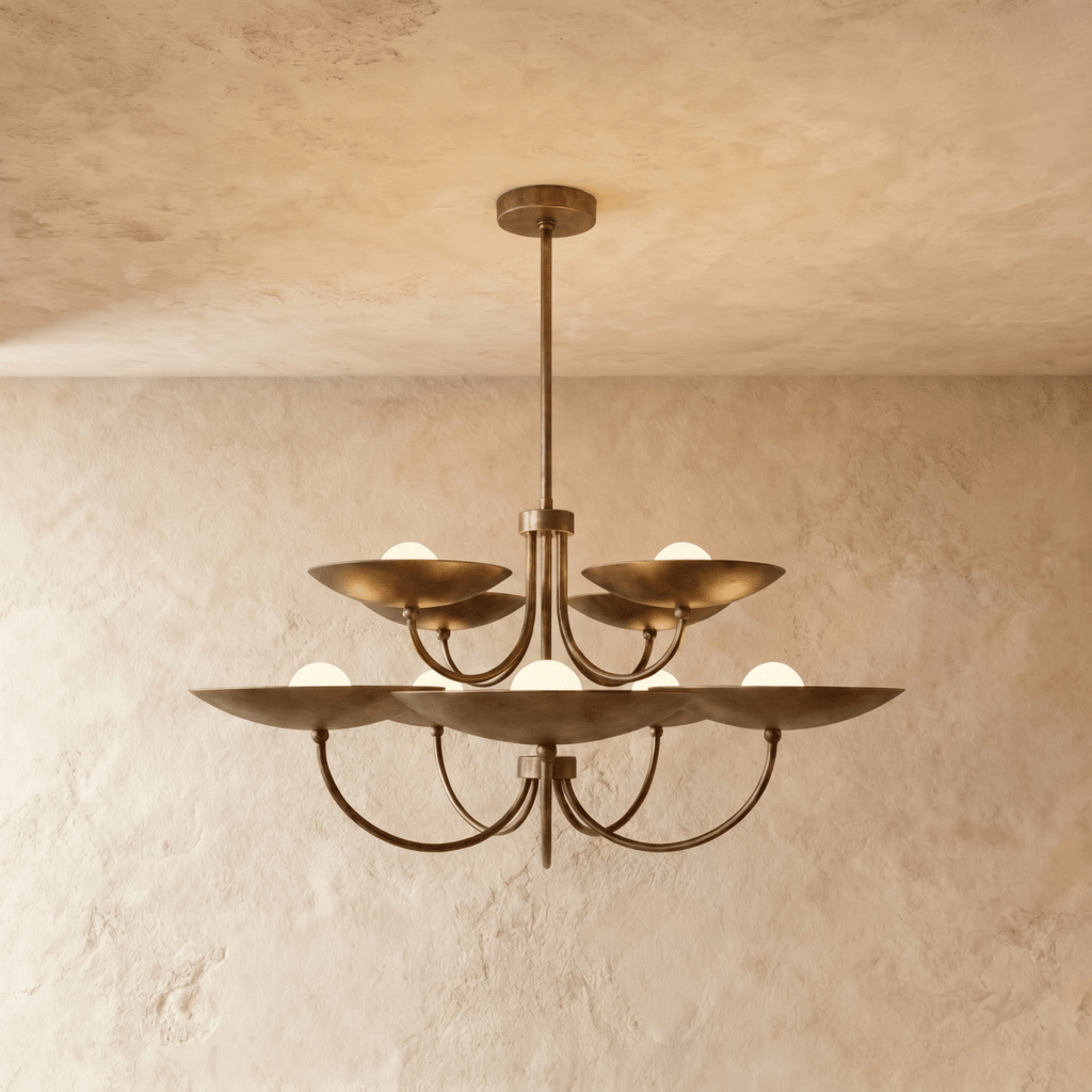 Clérachic two-tier disc chandelier in vintage brass with curved arms, hung from a plaster ceiling in studio light.