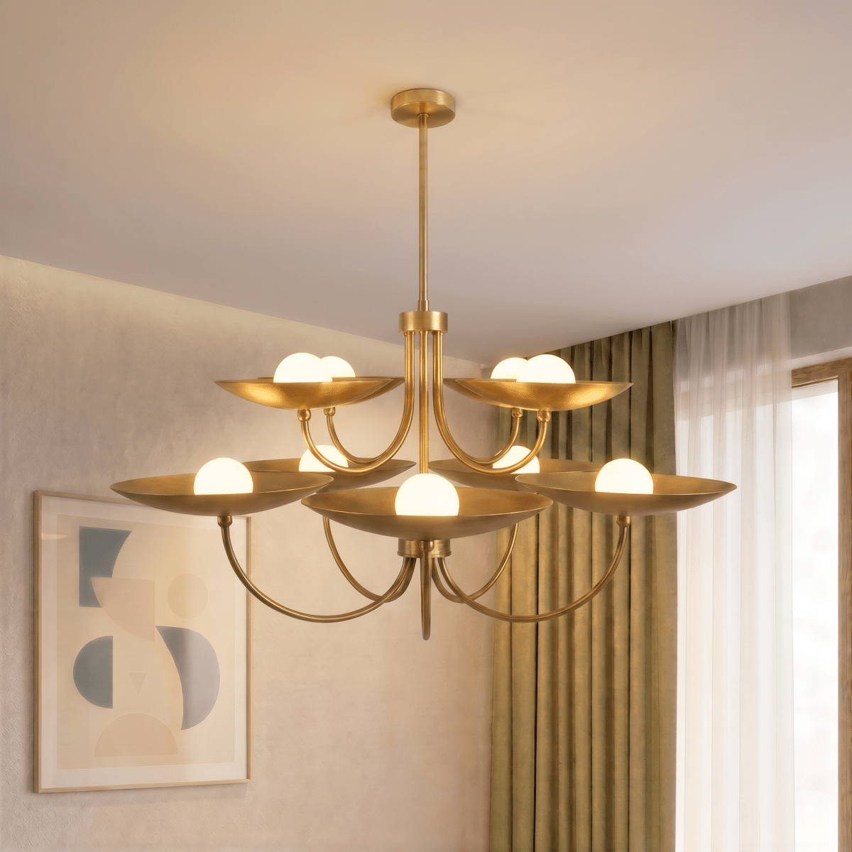 Clérachic brass two-tier disc chandelier lit above a living room with sheer curtains and abstract wall art.