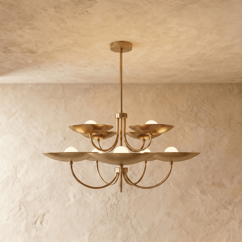 Clérachic two-tier disc chandelier in polished brass with curved arms, hung from a plaster ceiling in studio light.