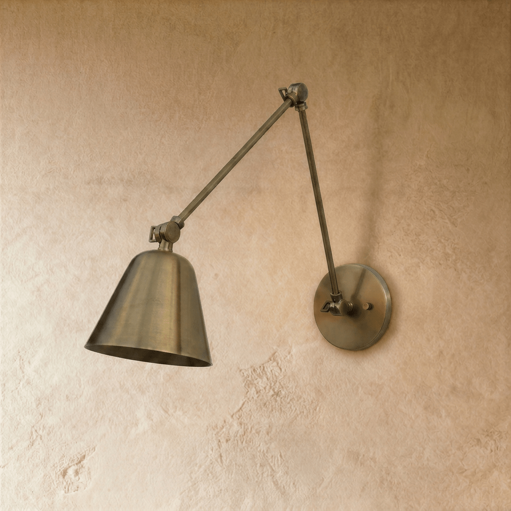 This Clérachic wall light in aged vintage brass shows the full swing-arm reach, shade tilted toward the floor.