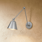 This Clérachic swing-arm wall light in brushed chrome extends its arm with the cone shade angled downward.