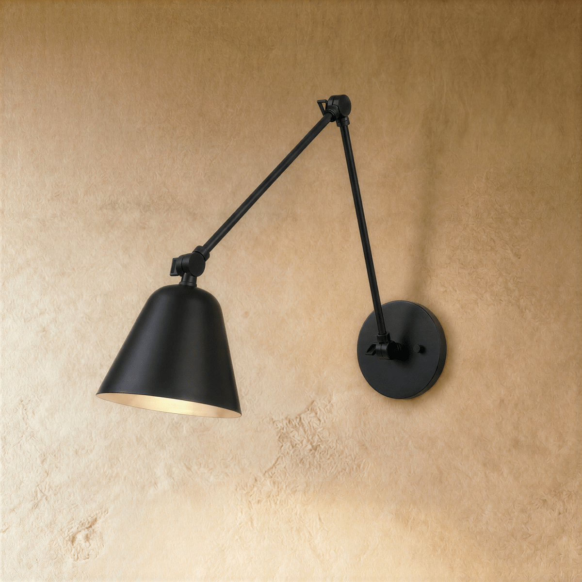 This Clérachic swing-arm wall light in matte black stands against a warm plaster wall, shade angled downward.