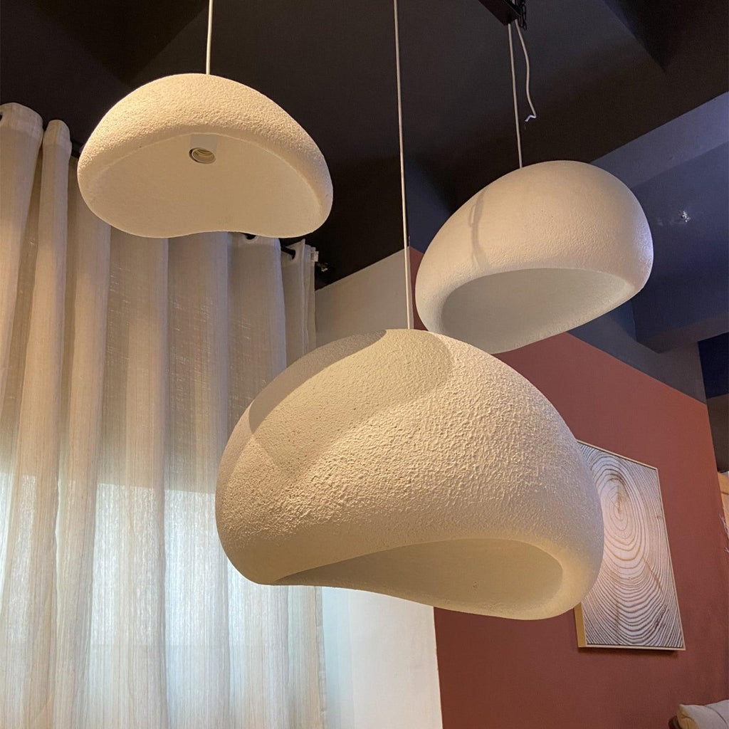 Wabi-sabi organic chandelier glowing softly in a neutral room