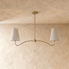 Clérachic double-arm chandelier in polished brass, the curved arms and cone shades viewed from another angle.