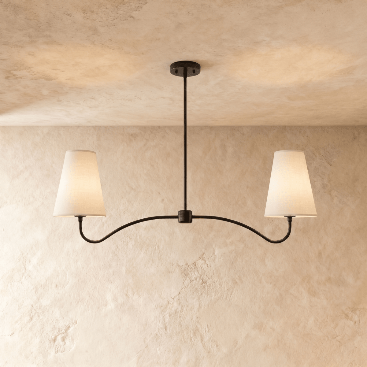 Clérachic double-arm chandelier in matte black, its linen cone shades hung from a plaster ceiling.