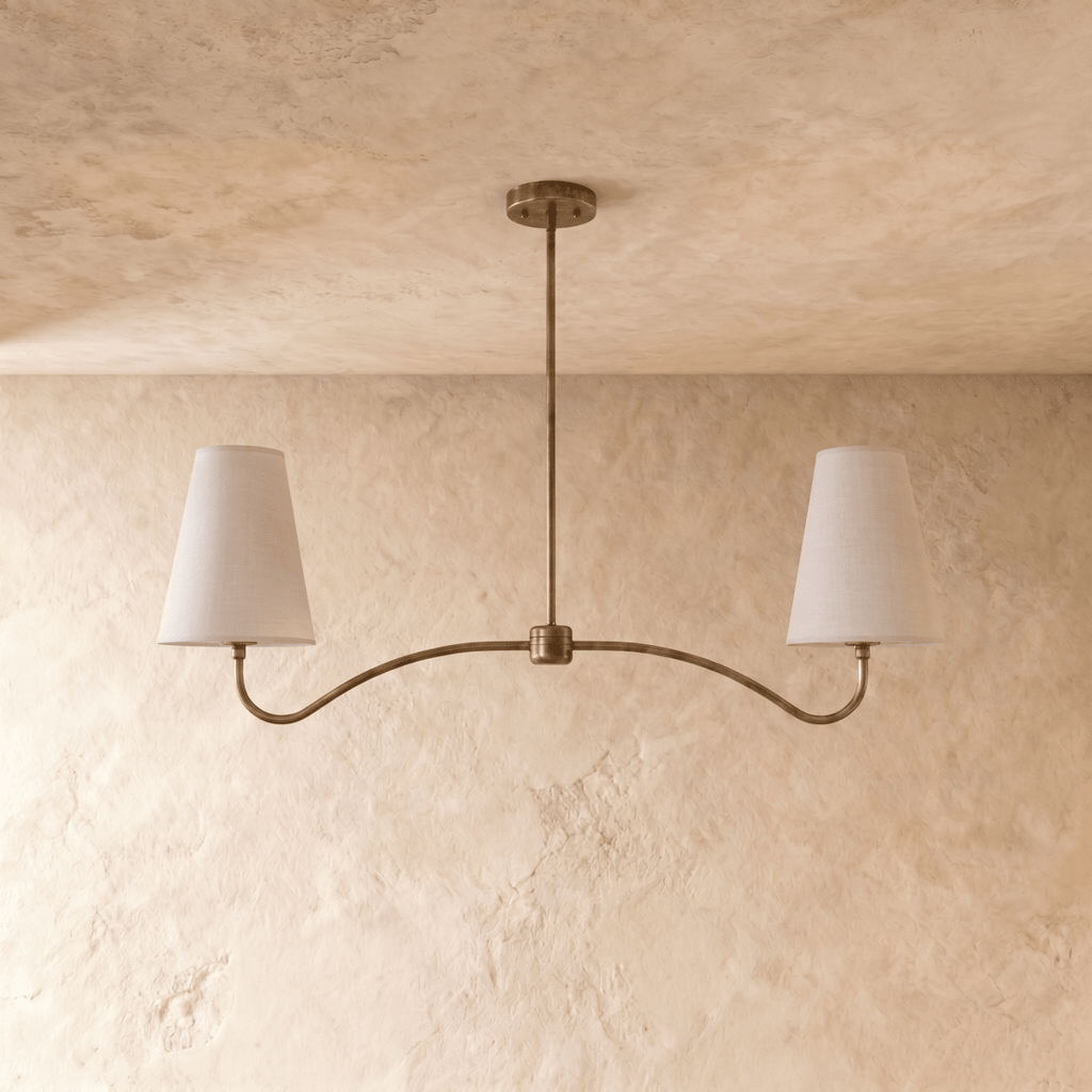 Clérachic double-arm chandelier in vintage brass, the curved arms and cone shades viewed from another angle.