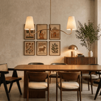 Clérachic vintage brass chandelier hanging above a dining table beside a gallery wall of framed folk-art prints.