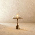 Clérachic glass dome table lamp, clear shade over a brushed metal cone base, lit warm