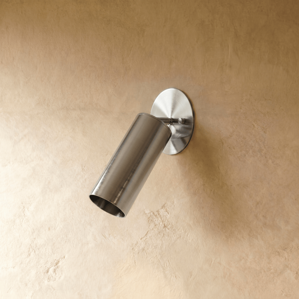 Clérachic wall lamp in chrome, close view of the tilted cylinder shade and slim mounting arm.
