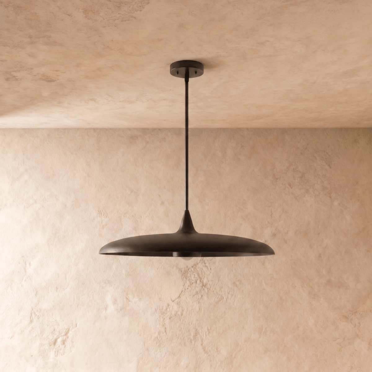 Clérachic pendant light in matte black, the saucer-shaped shade and rod viewed from a slightly different angle.