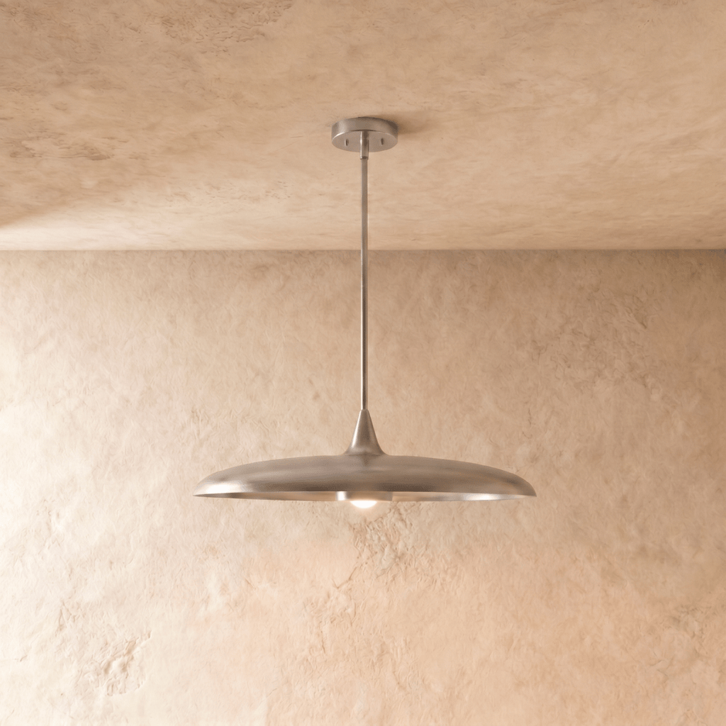 Clérachic pendant light in a bright chrome finish, its wide saucer shade hanging below a plaster ceiling.