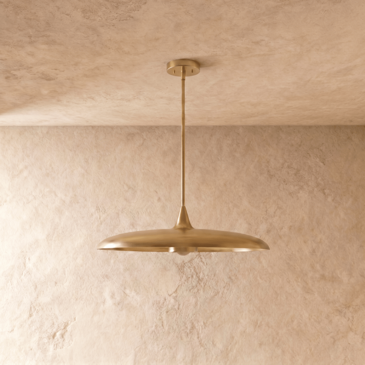 Clérachic pendant light in polished brass, the saucer shade and slender rod shown from another angle.