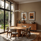 Clérachic chrome saucer pendant light glowing above a round table, beside framed animal prints near a garden view.