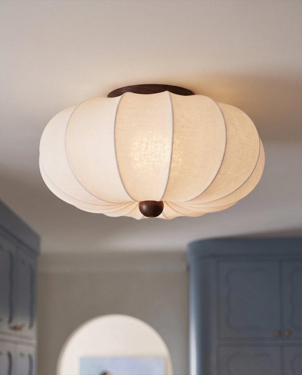Clérachic ceiling light glowing above a hallway between blue cabinetry and an arched doorway.