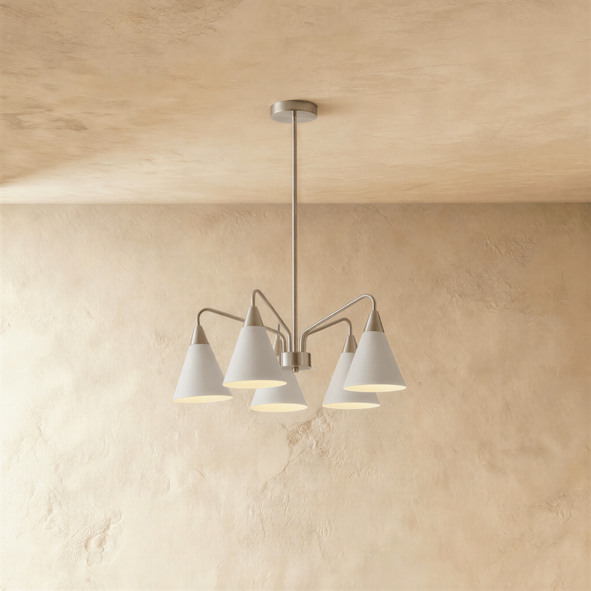 This Clérachic chandelier hangs from a plaster ceiling with five cone shades fanned out in soft white metal.