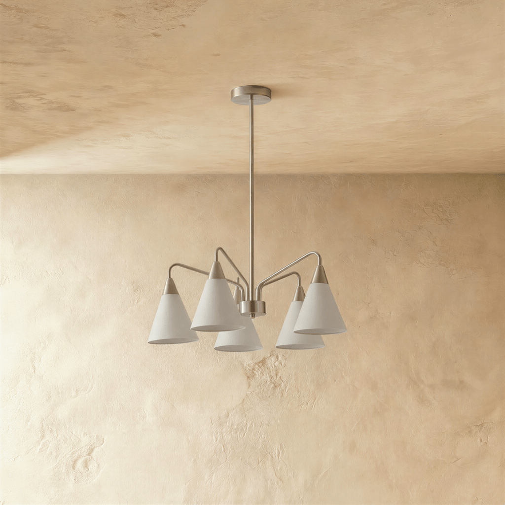 A Clérachic chandelier drops from the ceiling on a slim rod, its five white cone shades angled outward.
