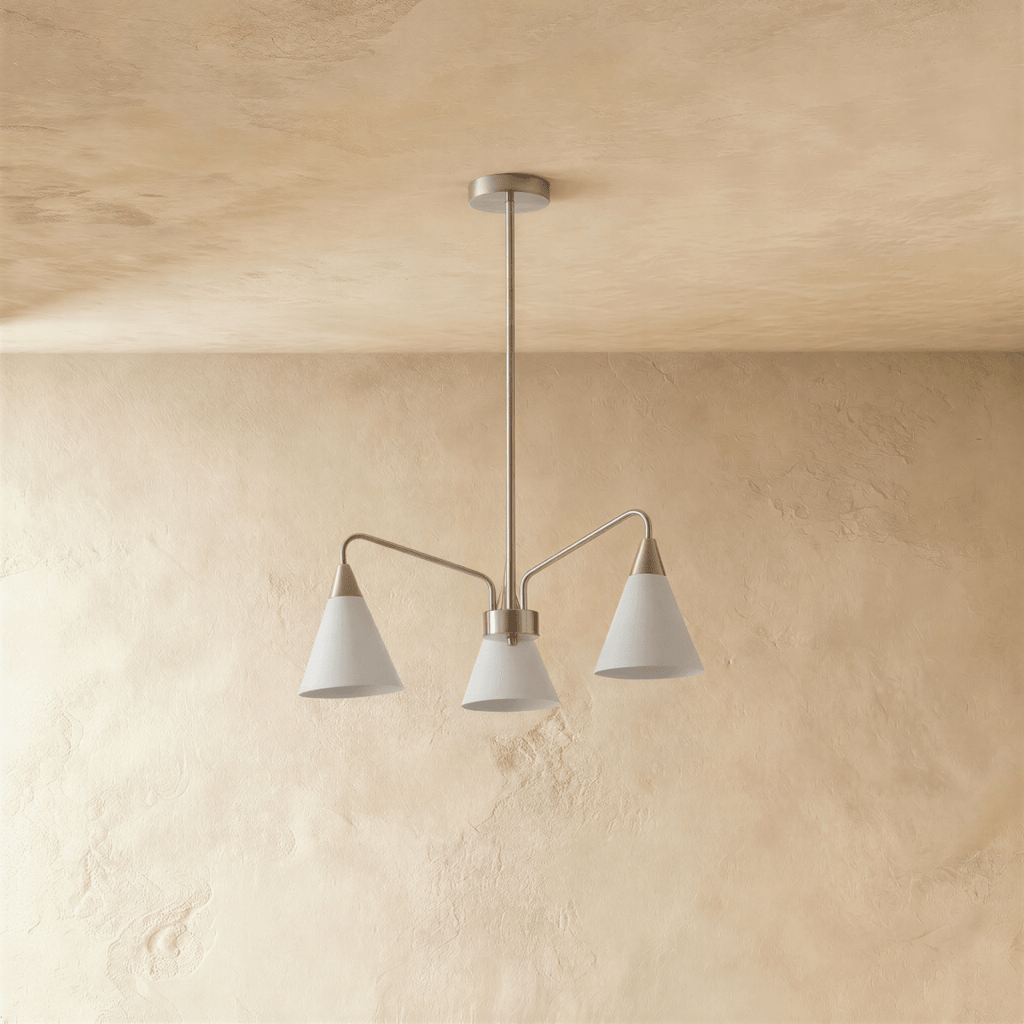 A Clérachic chandelier with three white cone shades hangs from a slim rod against a textured plaster wall.