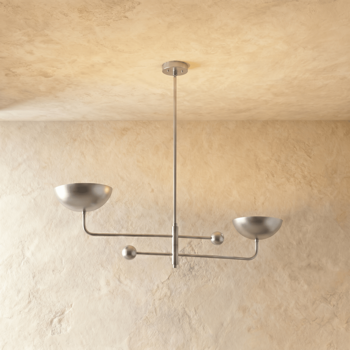 Clérachic chandelier in a bright chrome finish, its two balanced arms and bowl shades against a plaster ceiling.