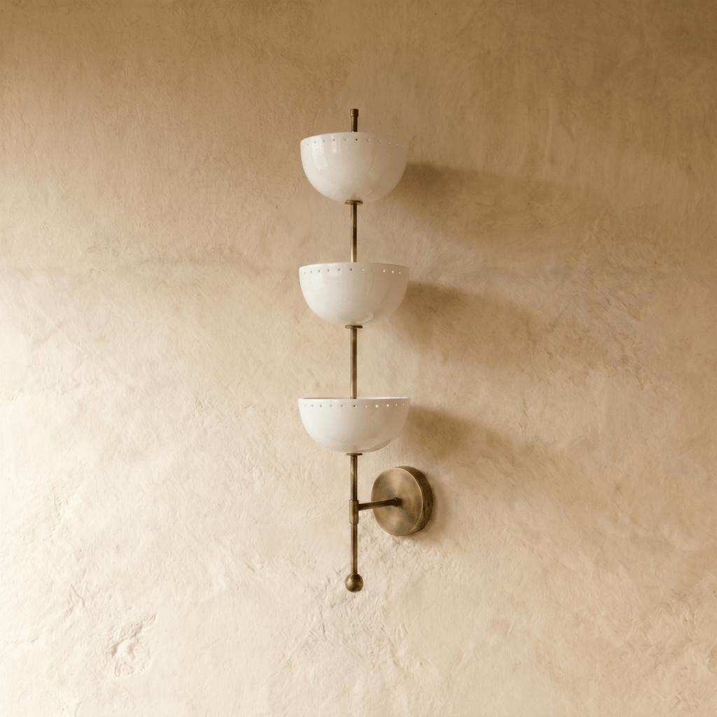 Clérachic three-tier bowl sconce in vintage brass, shown from a slightly closer studio angle on a plaster wall.