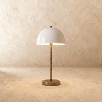Clérachic table lamp in vintage brass with a glossy white dome shade on a slender stem and round base.