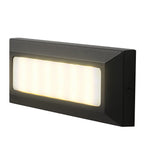 Angled studio view of the light lit warm, showing the slim wedge profile and side fixing screw.