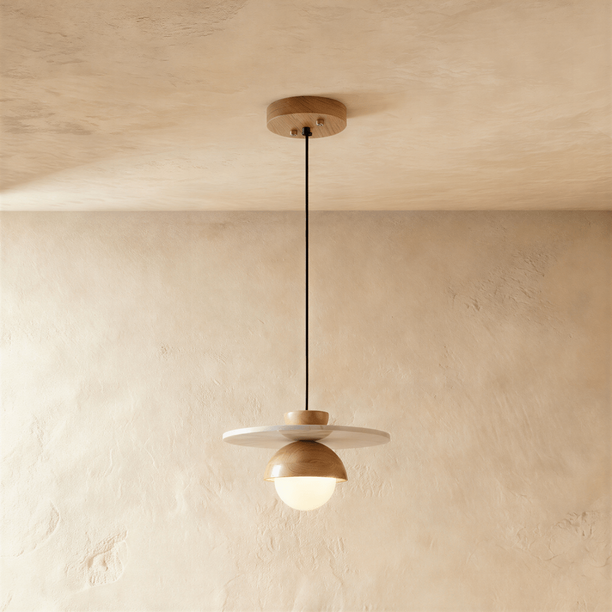 Clérachic pendant light in a light wood finish, a round opal glass globe glowing beneath a wide flat disc.