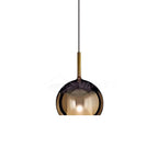 Blown glass globe pendant light hanging over a side table