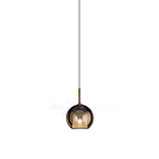 Glass globe pendant light with soft reflective surface lit