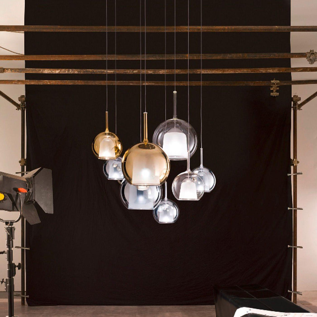 Glass globe pendant light glowing above a styled console