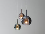 Tinted glass globe pendant light glowing above a seating area