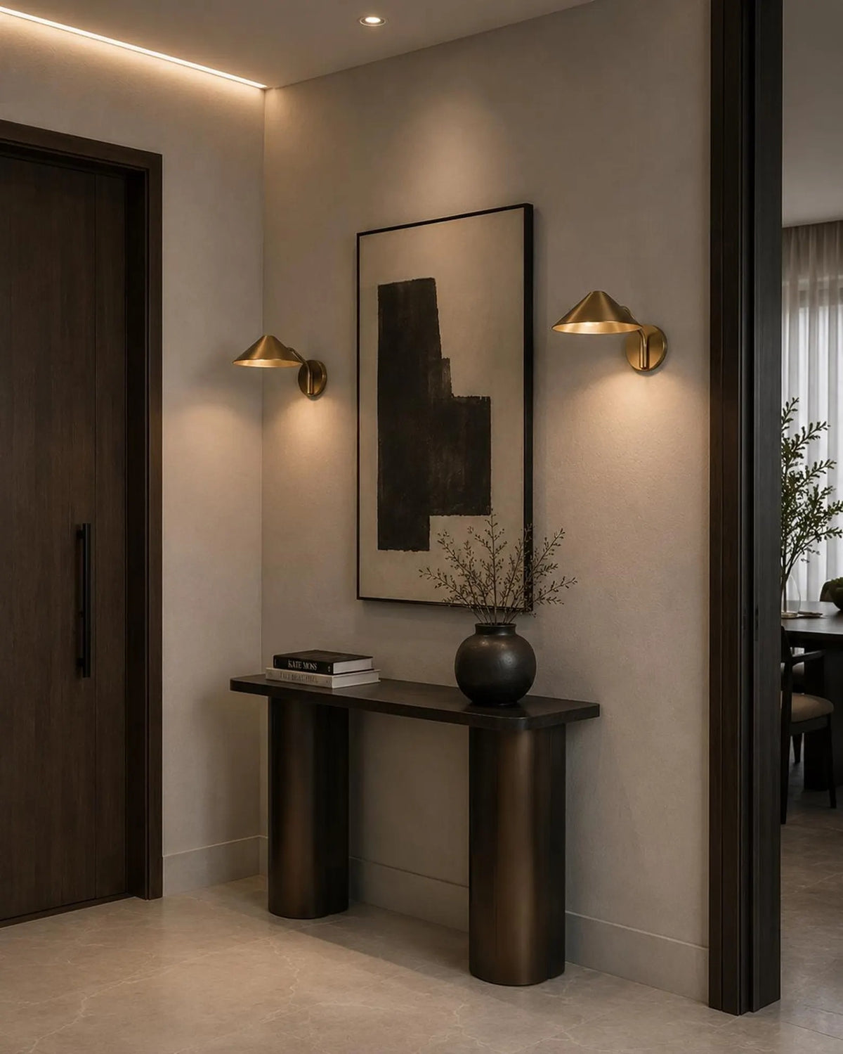 Video: a pair of Clérachic brass cone-shade wall lights glowing either side of framed art in a hallway