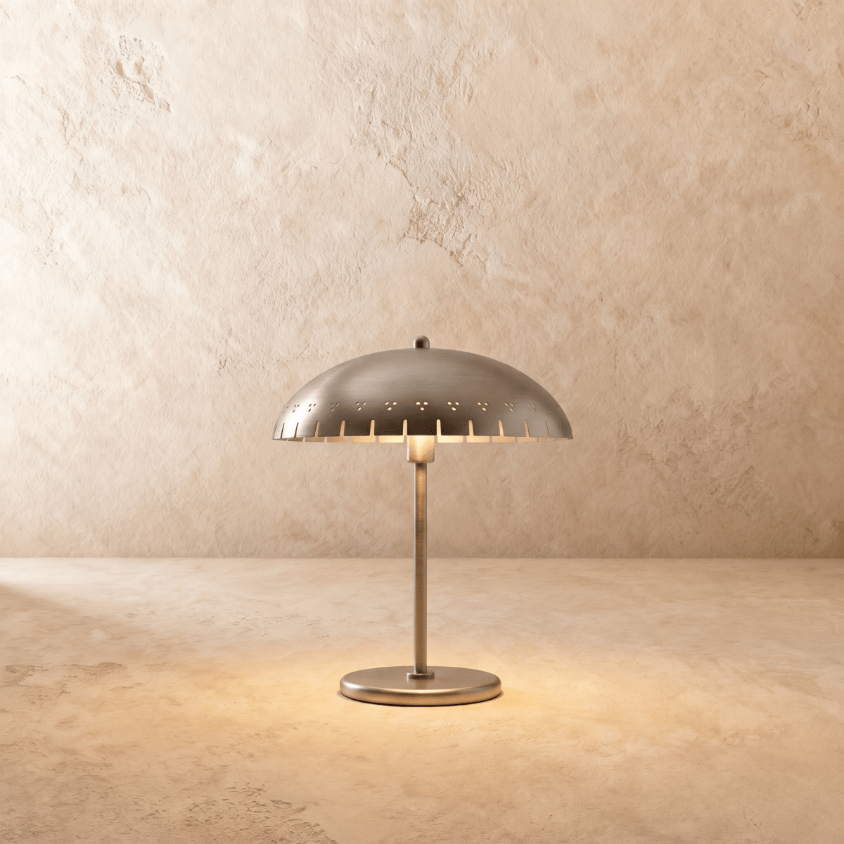 Clérachic table lamp in chrome, a perforated dome shade set on a slender stem and round base.
