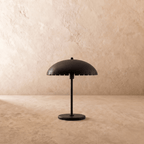 Clérachic table lamp in matte black, close view of the perforated dome shade and slim metal stem.