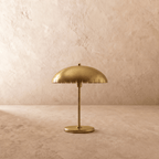 Clérachic table lamp in satin brass, front view of the perforated dome shade and round base.